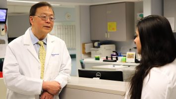 Donald Leung, MD consults with a colleague at National Jewish Health. Dr. Leung is leading a clinical trial to test a skin lotion containing beneficial bacteria that kills harmful bacteria on the skin of eczema patients.